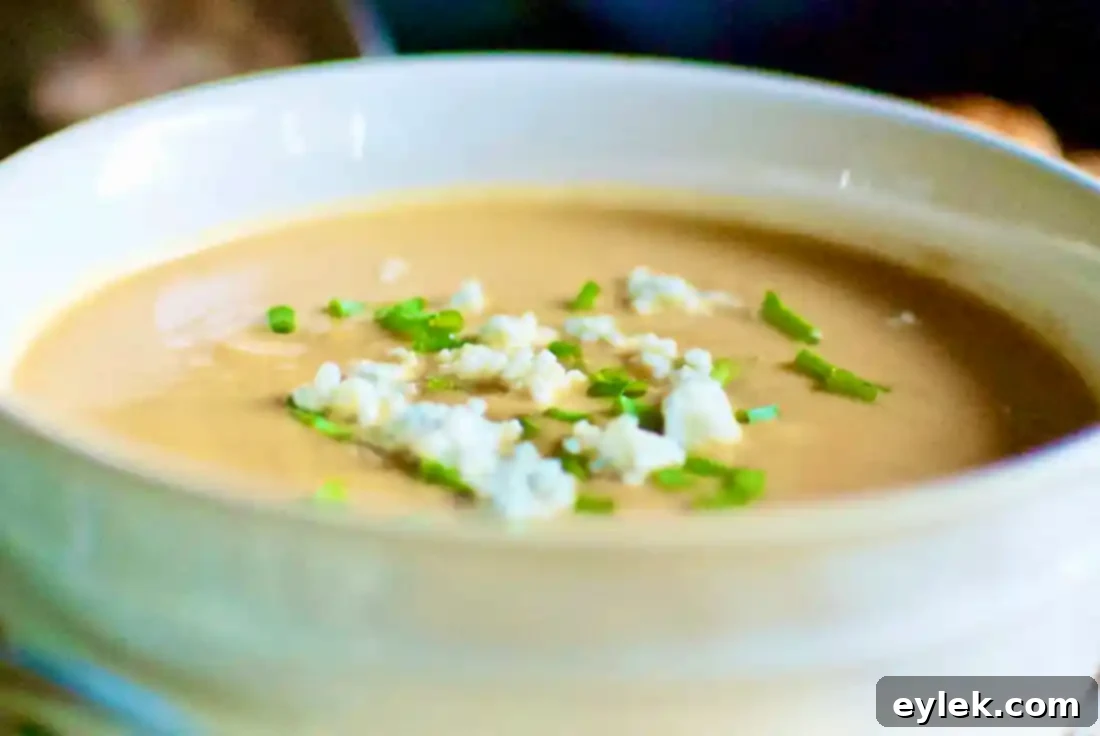 Close-up of a bowl of Roasted Pear & Butternut Squash Bisque with garnishes