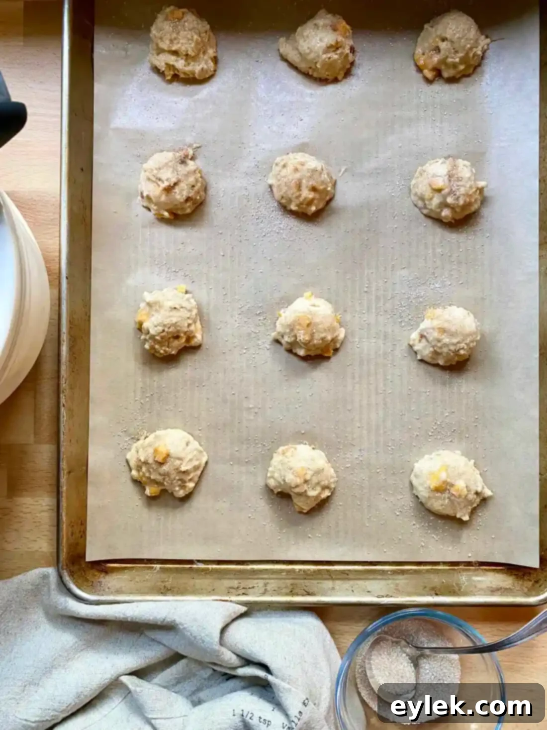 Cakey Peach Drop Cookies 11 Unbaked peach cake drop cookies on a baking sheet, sprinkled with sugar