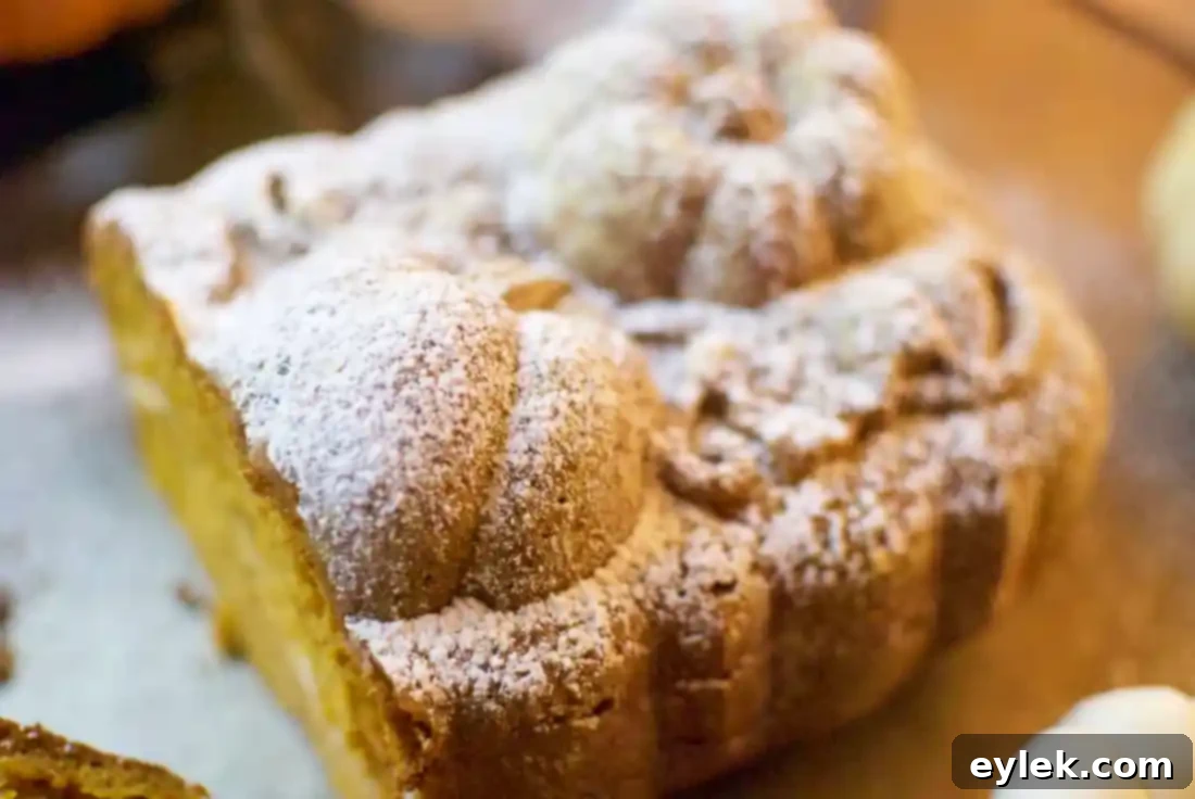 Gluten-free pumpkin bread with cream cheese filling, lightly dusted with powdered sugar