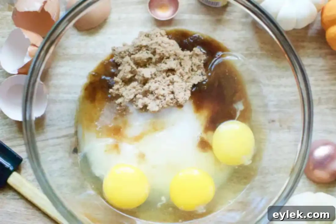 Wet ingredients for gluten-free pumpkin bread batter, including eggs, sugars, and vanilla