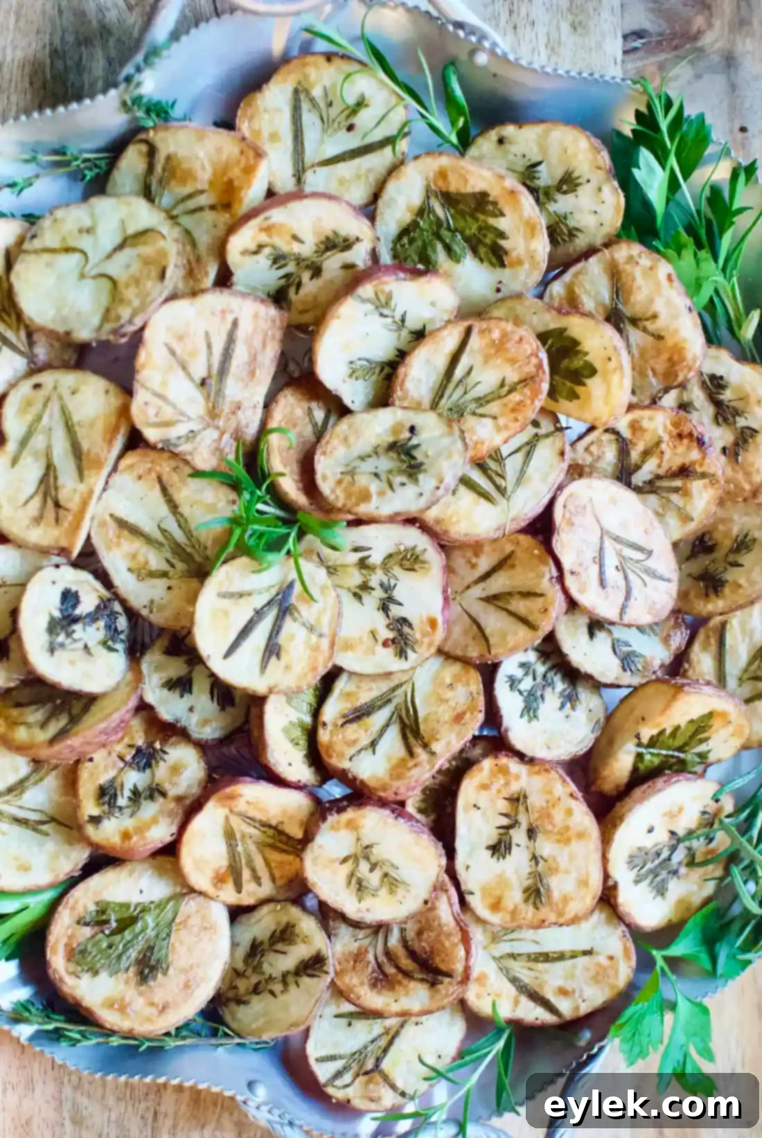 Vertical shot of Dressed-Up Herb Roasted Potatoes on a wooden board