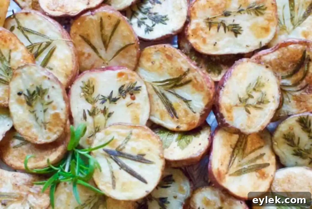 Dressed-Up Herb Roasted Potatoes served in a white dish, garnished with fresh herbs