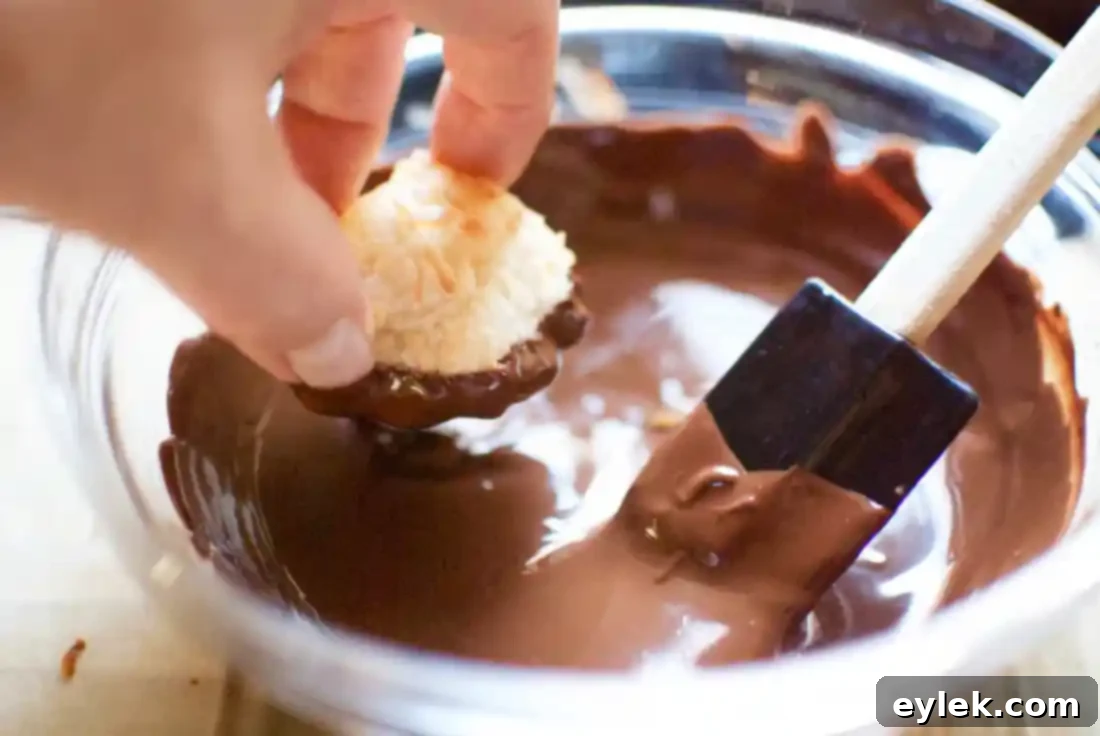 Dipping macaroons in melted chocolate