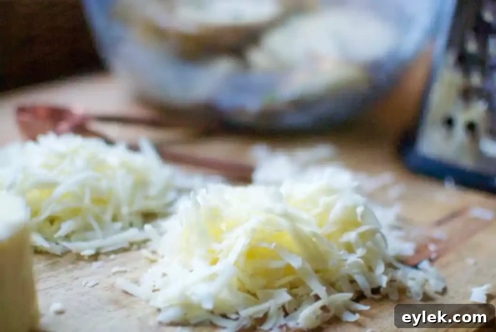 Close-up of freshly grated Asiago and sharp cheddar cheese for potato stacks.