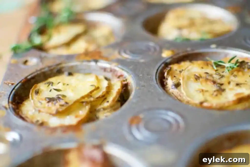Cooked cheesy potato and herb stacks, golden and crispy, fresh out of the oven.
