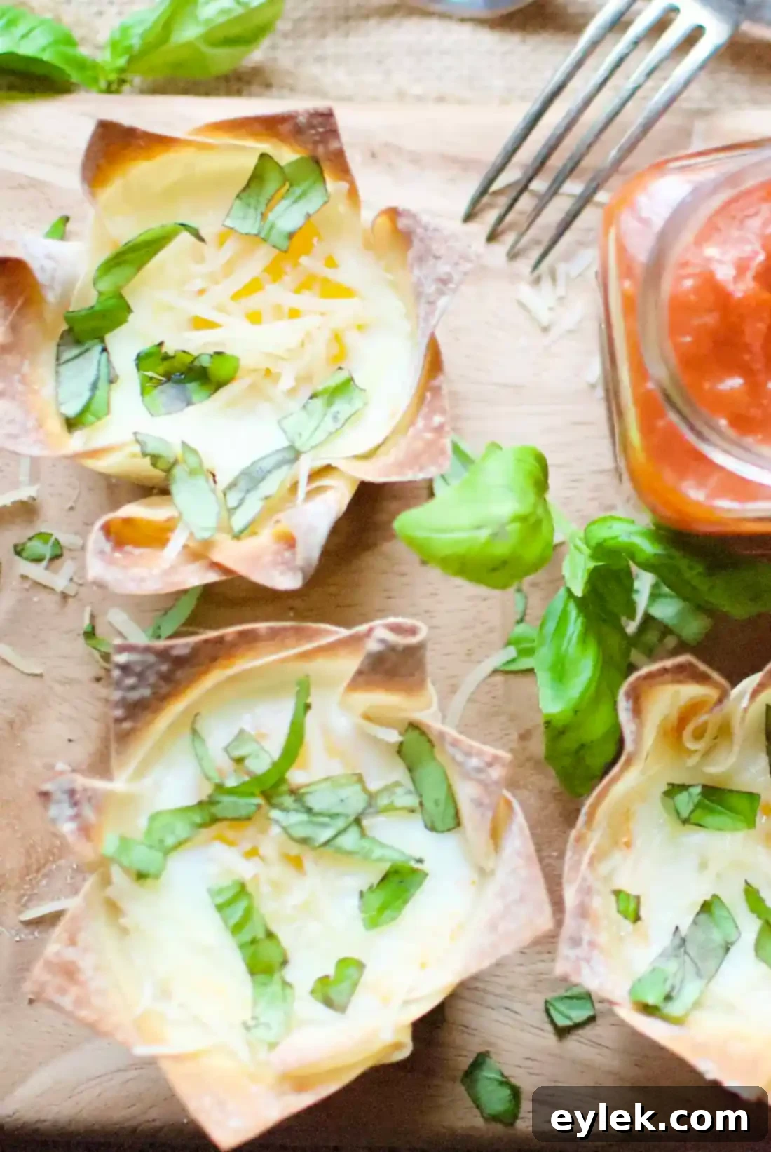 A beautifully plated Italian Egg Wonton Cup, showing the golden-brown wonton, marinara, melted mozzarella, and a perfectly cooked egg with fresh basil.