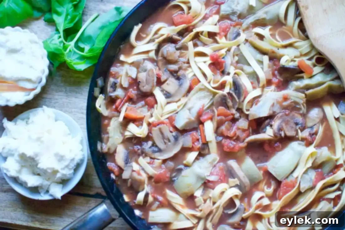 One-pan pasta simmering with artichokes, mushrooms, and tomatoes