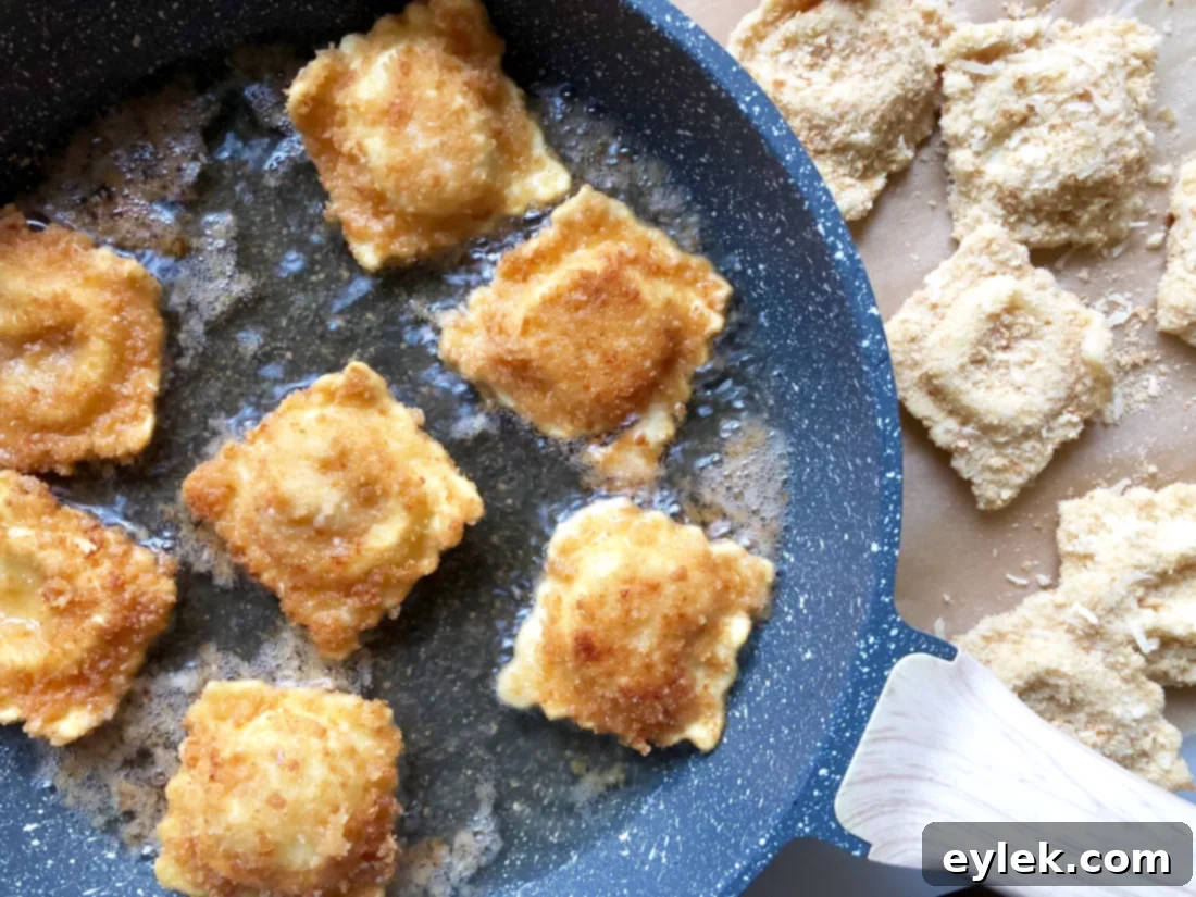 Ravioli coated in breadcrumbs, ready to be fried