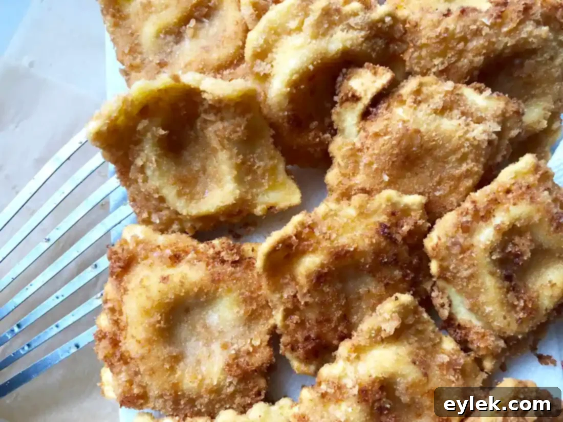 Crispy fried ravioli browning in hot oil in a skillet