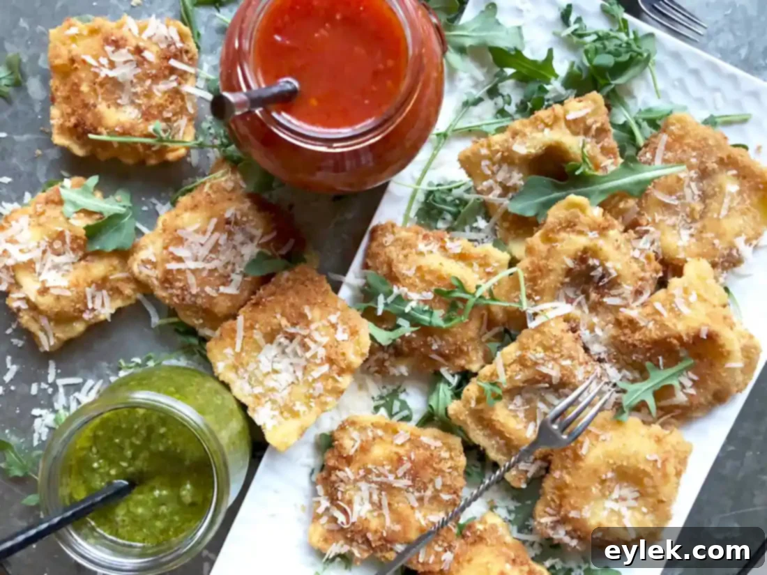 Crispy Fried Cheese Ravioli garnished with arugula and served with dipping sauces on a platter