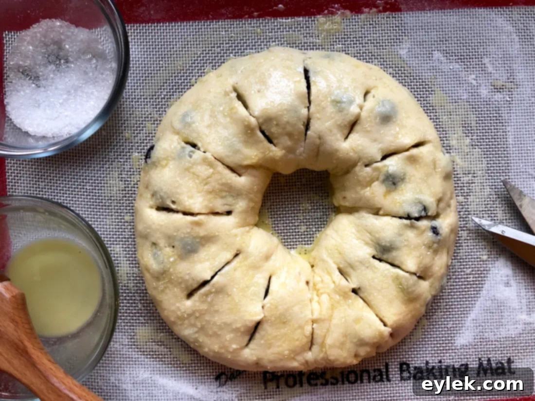 Unbaked Gluten-Free Blueberry & Lemon Curd Ring, brushed with egg wash and sprinkled with coarse sugar, with cuts made.