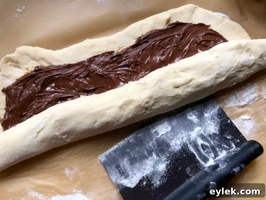 Gluten-Free brioche dough rolled into a log with Nutella swirl visible