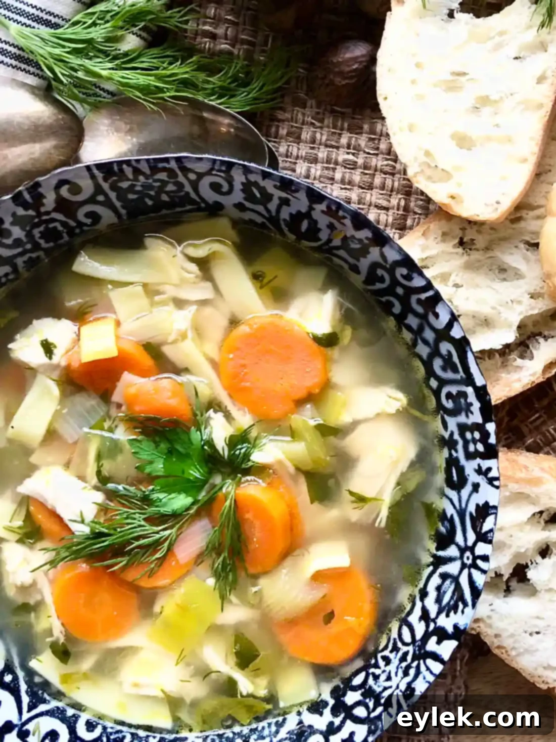 The Best Quick & Easy Chicken Noodle Soup in a bowl with crusty bread.