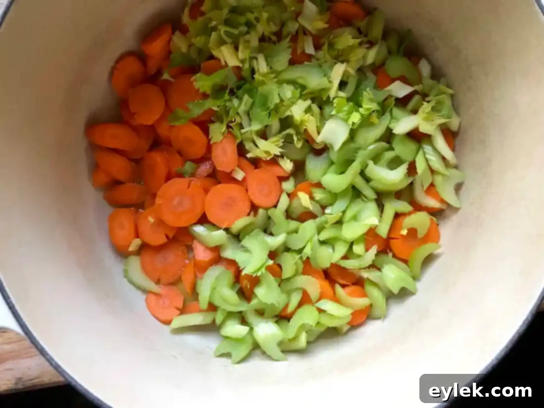 Celery and carrots sautéing in a pot with butter and olive oil.