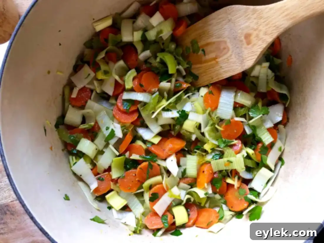 The chicken broth and vegetables boiling in the large pot.