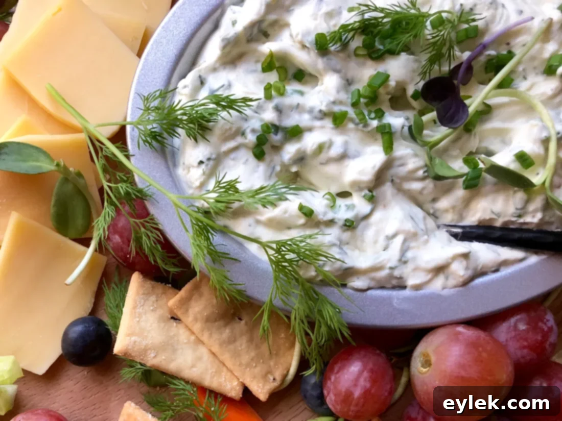 Creamy Herbed Dip with Lemon and Dill on a serving platter with vegetables and breadsticks