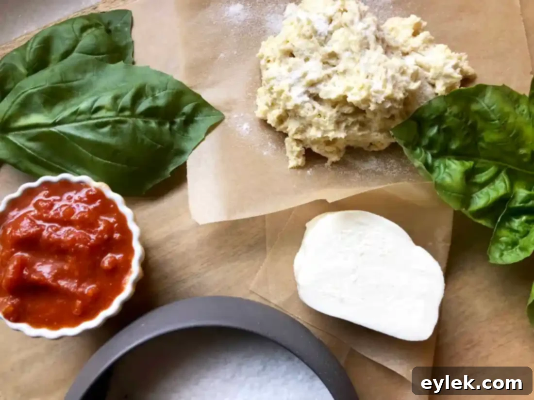 A small portion of gluten-free pizza dough ready to be shaped on parchment paper.