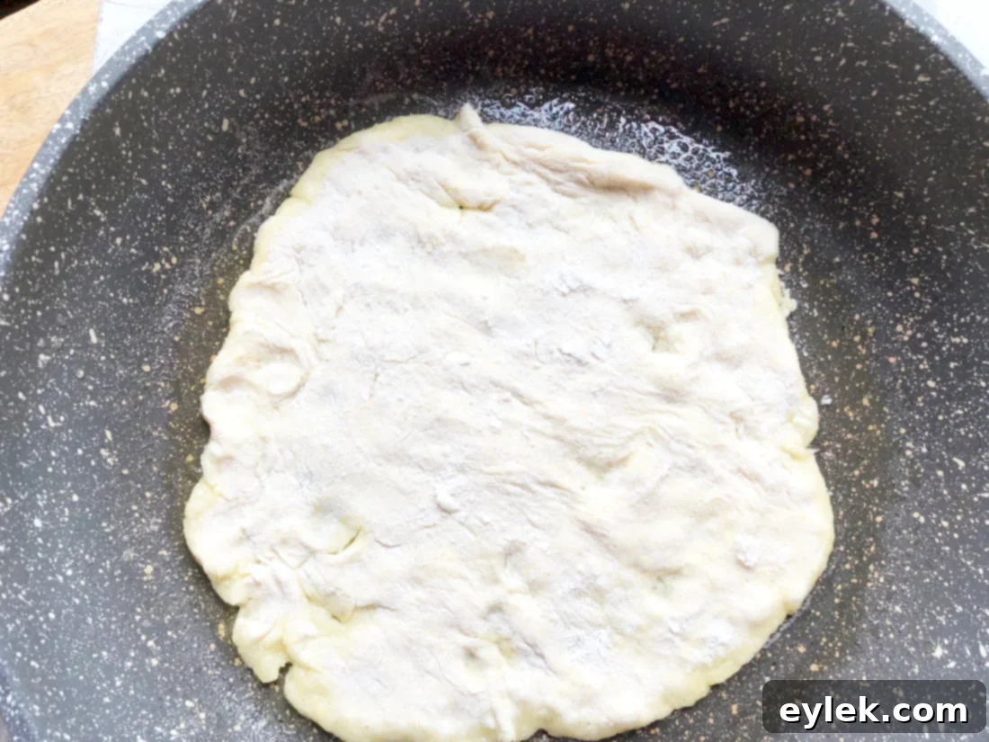 four shaped gluten-free naan dough portions on a board