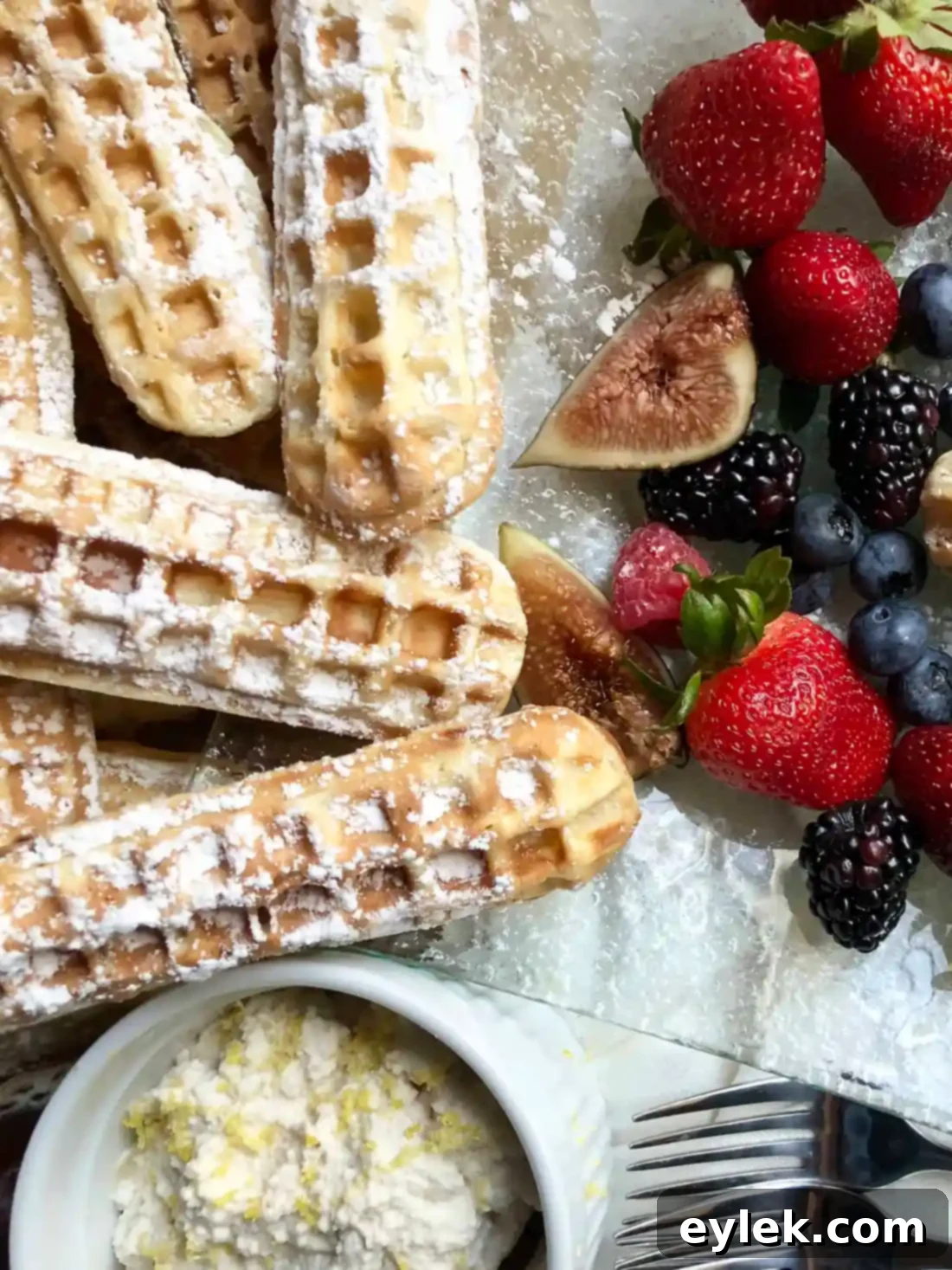 Close-up of chocolate chip waffle sticks with powdered sugar and a side of Nutella