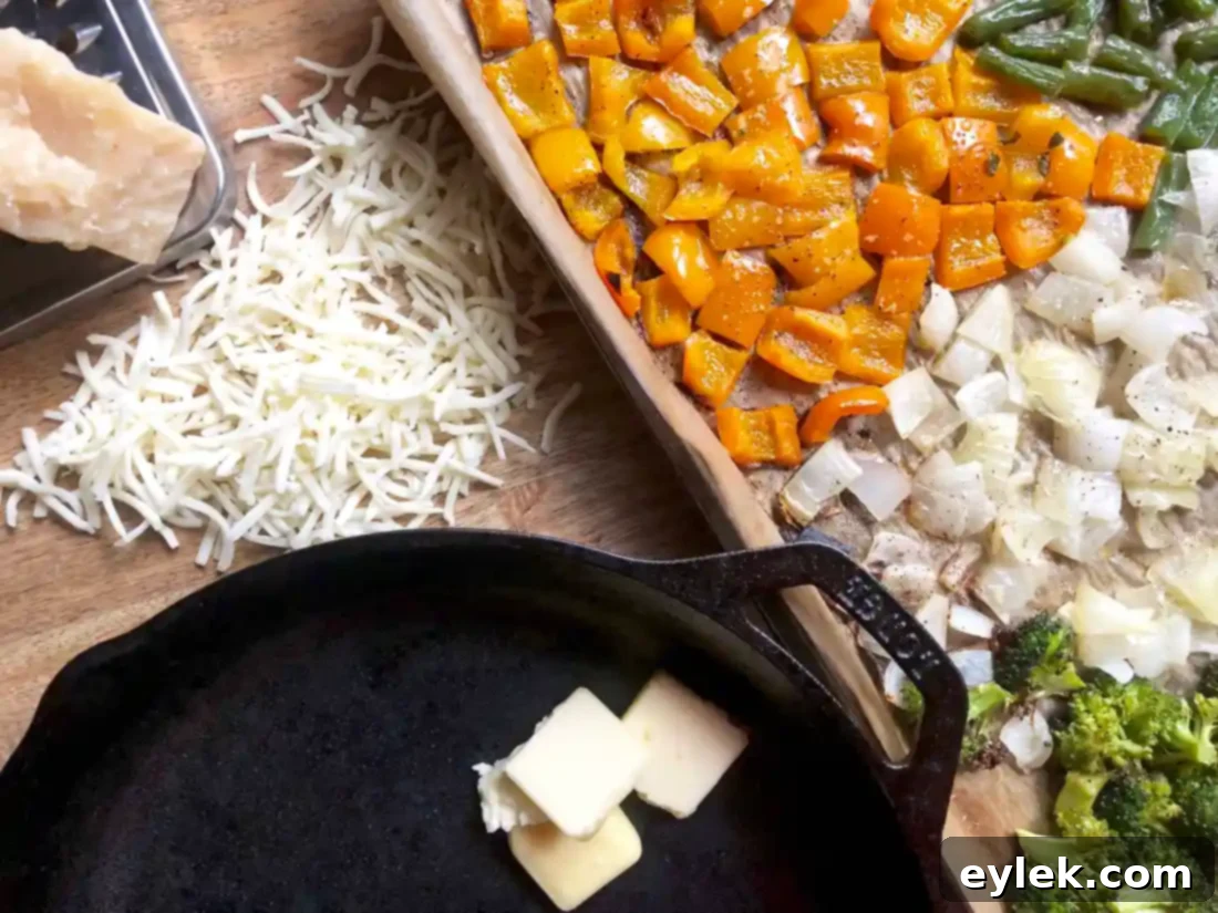 roasted vegetables being mixed with butter and cheese in a skillet