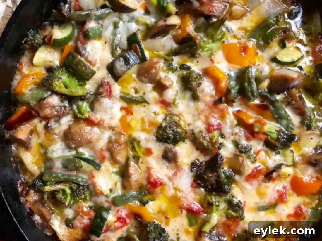 close-up of the cheesy roasted ratatouille dip in a skillet, bubbling and golden