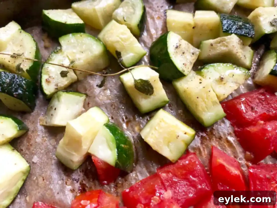 roasted zucchini and tomatoes on a baking sheet