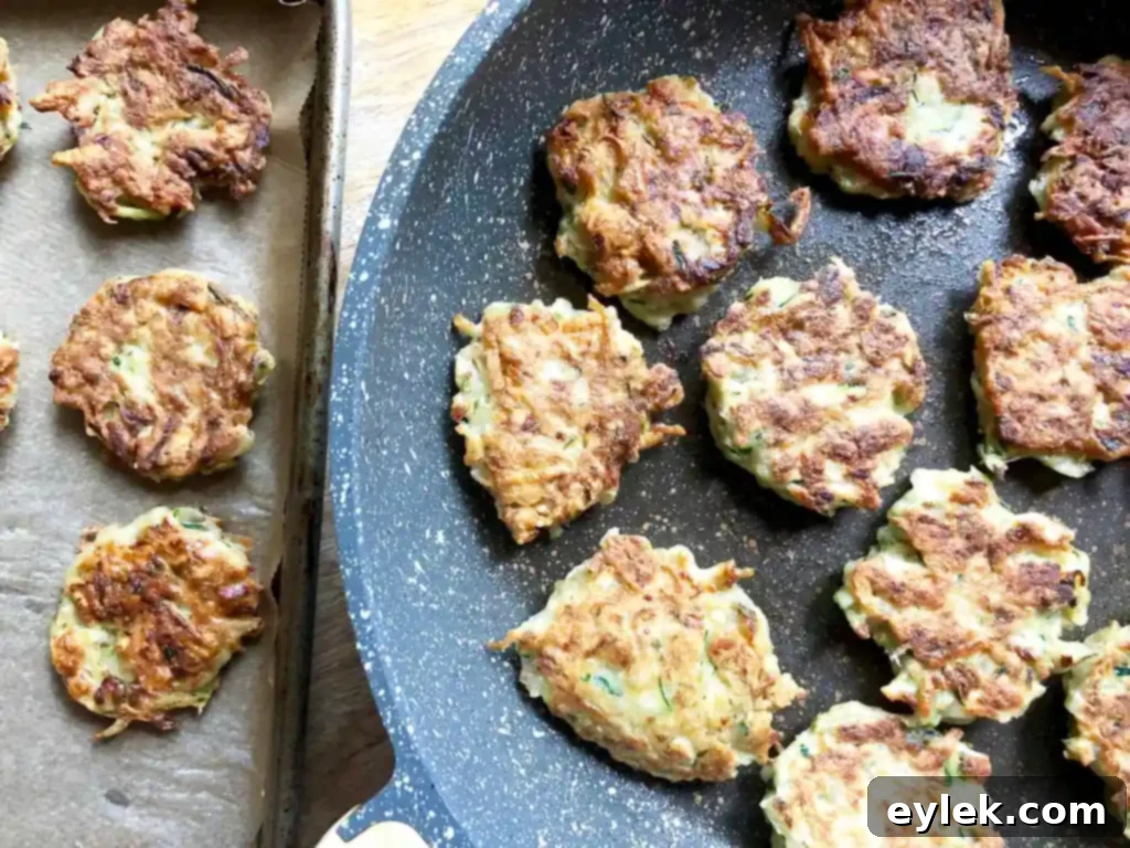 zucchini fritters frying in a pan