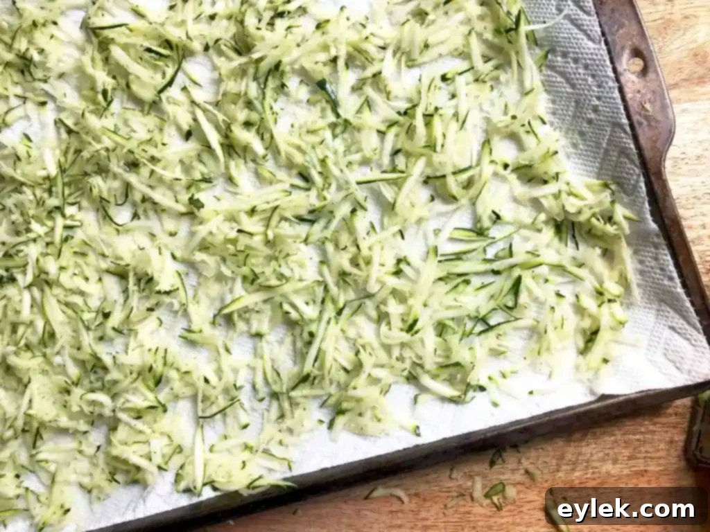 squeezing excess moisture from shredded zucchini