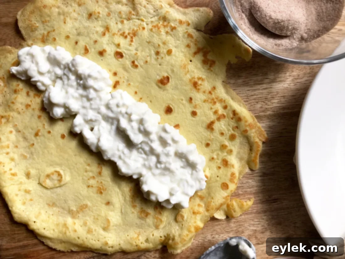 Low-carb crepes filled with cottage cheese, rolled, and dusted with cinnamon