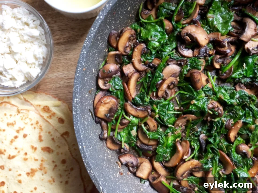 Bowl of savory crepe filling with spinach, mushrooms, and herbs