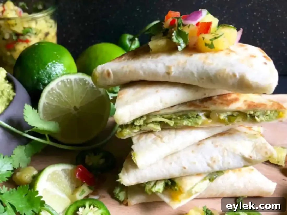 Assortment of chicken fajita quesadilla wedges on a white serving tray.