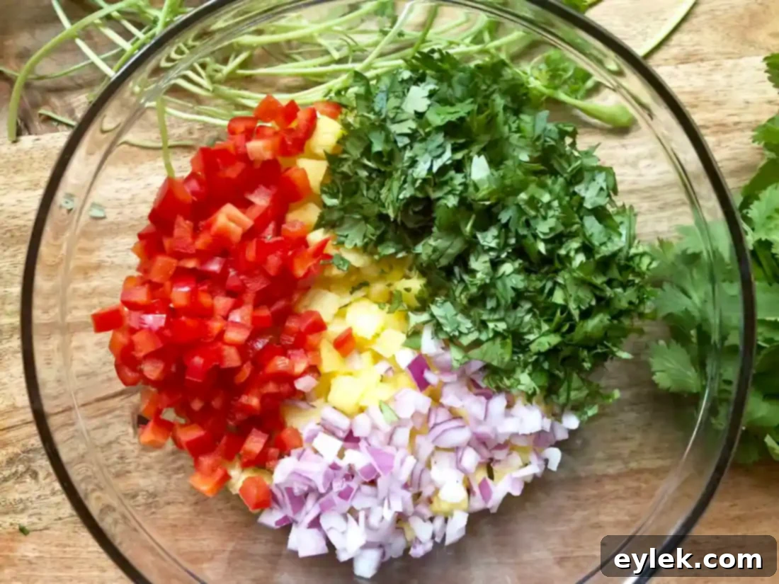 Prepared pineapple salsa in a white bowl, garnished with cilantro.