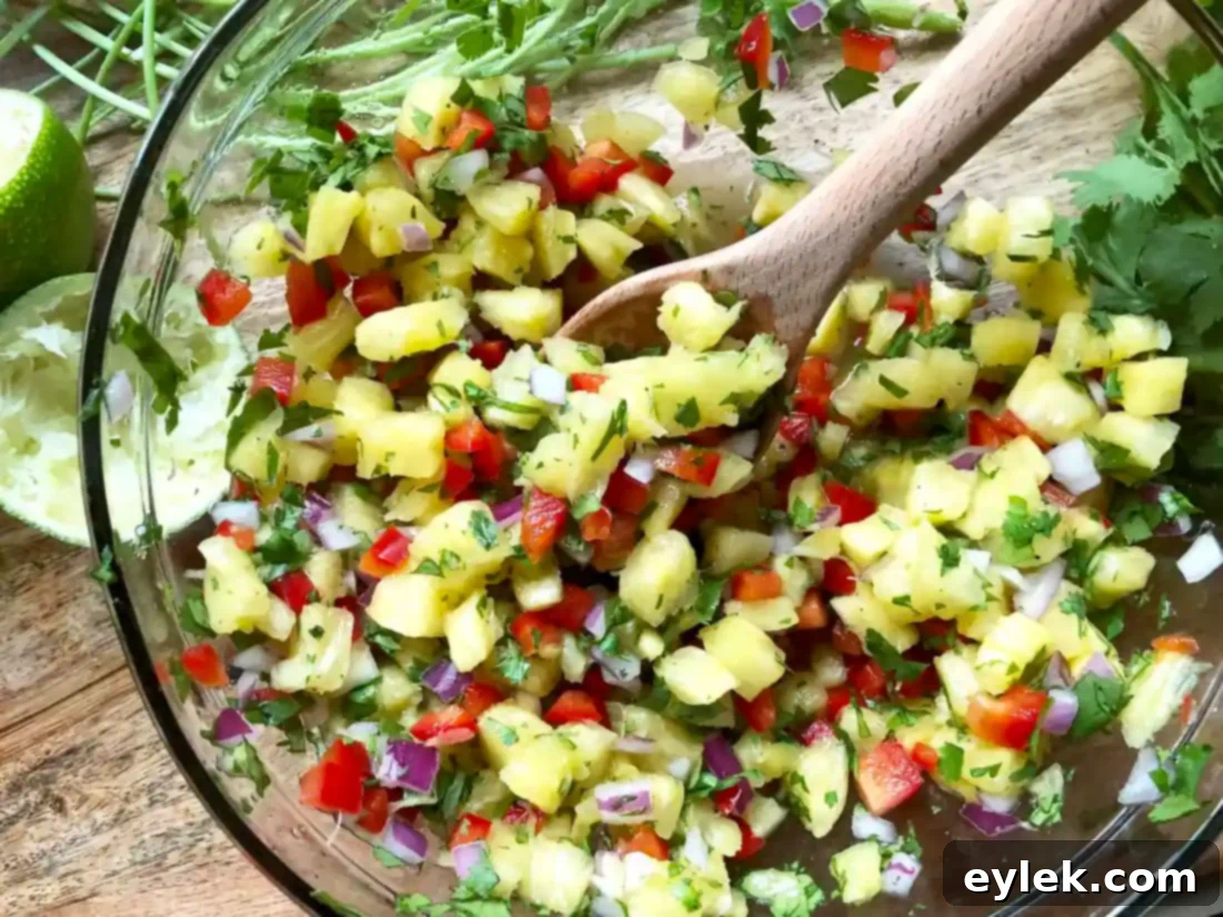 Freshly prepared pineapple salsa in a bowl with a serving spoon.