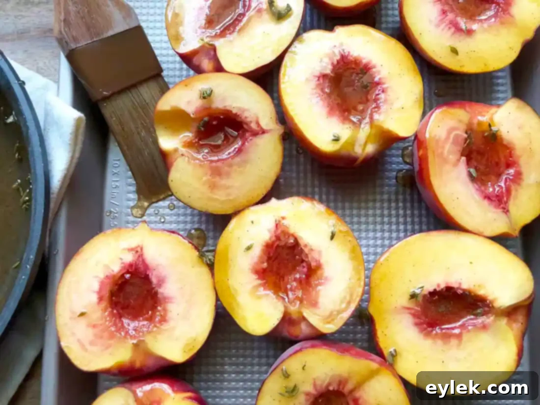 Peach halves being brushed with the honey glaze before grilling