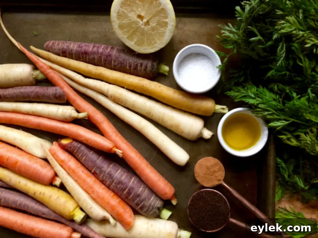 Rainbow carrots tossed with olive oil and spices on a baking sheet