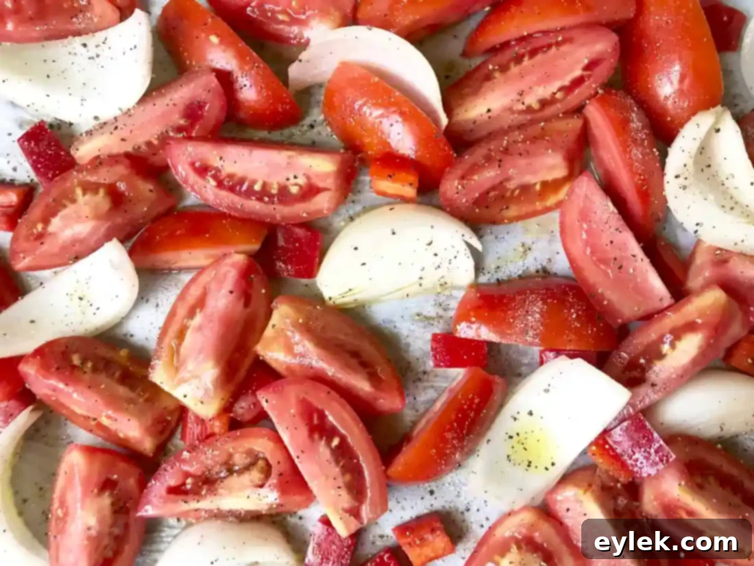 Roasted tomatoes, onions, and red bell peppers with garlic cloves added for the final stage of roasting for creamy tomato soup.