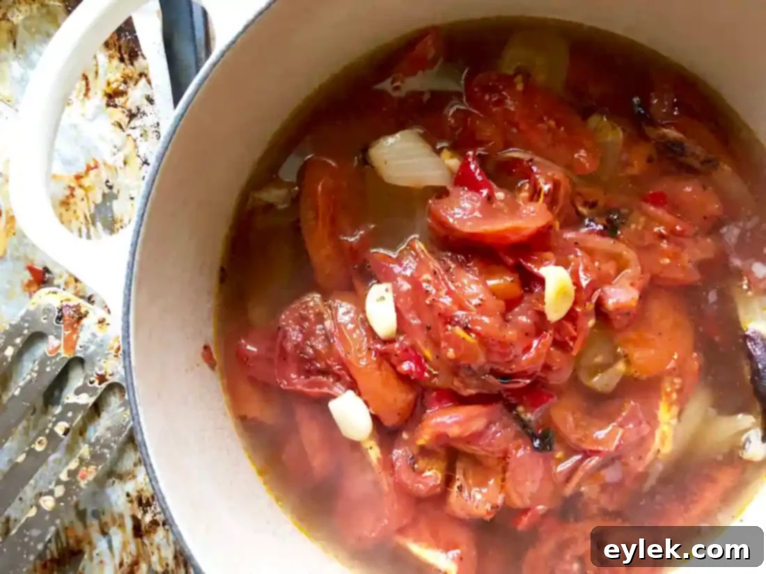 Smooth and creamy roasted tomato soup in a pot, ready for finishing touches.
