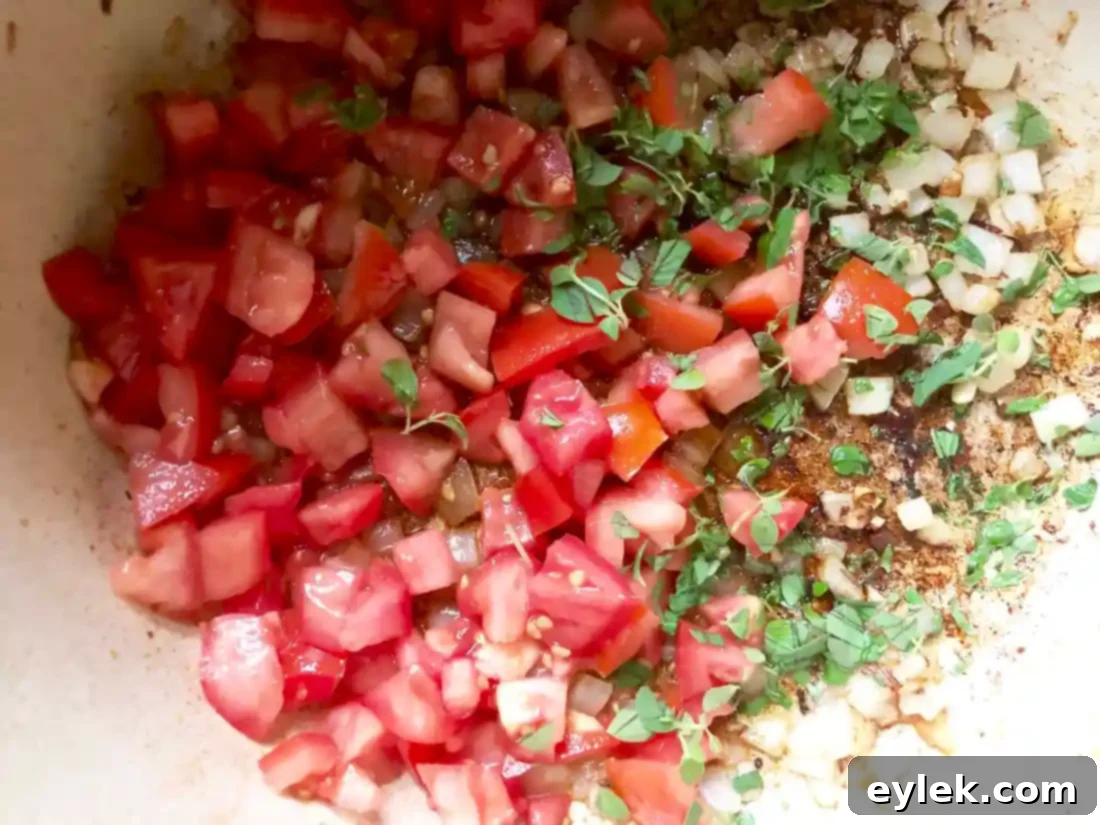 Adding chicken broth to the soup ingredients