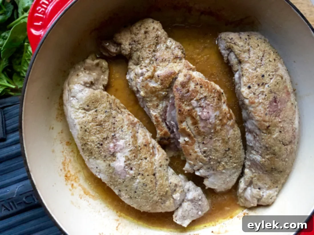 Pork tenderloin searing in a hot skillet