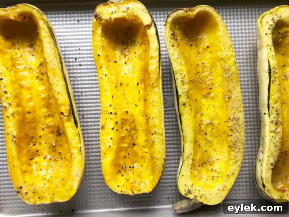 Savory Sausage Stuffed Delicata Squash 13 Two baked Sausage Stuffed Delicata Squash halves on a plate.