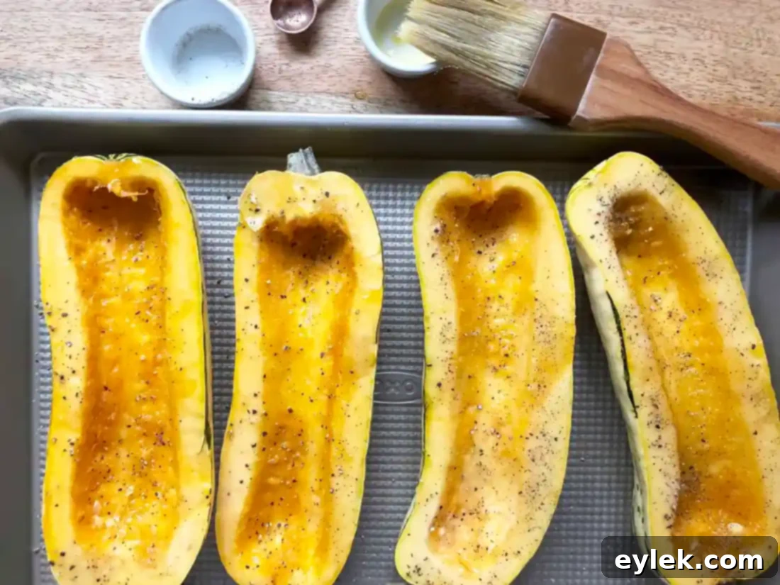 Savory Sausage Stuffed Delicata Squash 4 Delicata squash halves seasoned and arranged on a baking sheet.