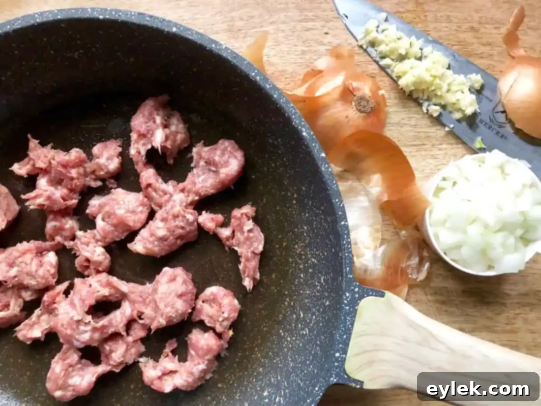 Savory Sausage Stuffed Delicata Squash 7 Sausage, onion, and garlic cooking in a skillet.