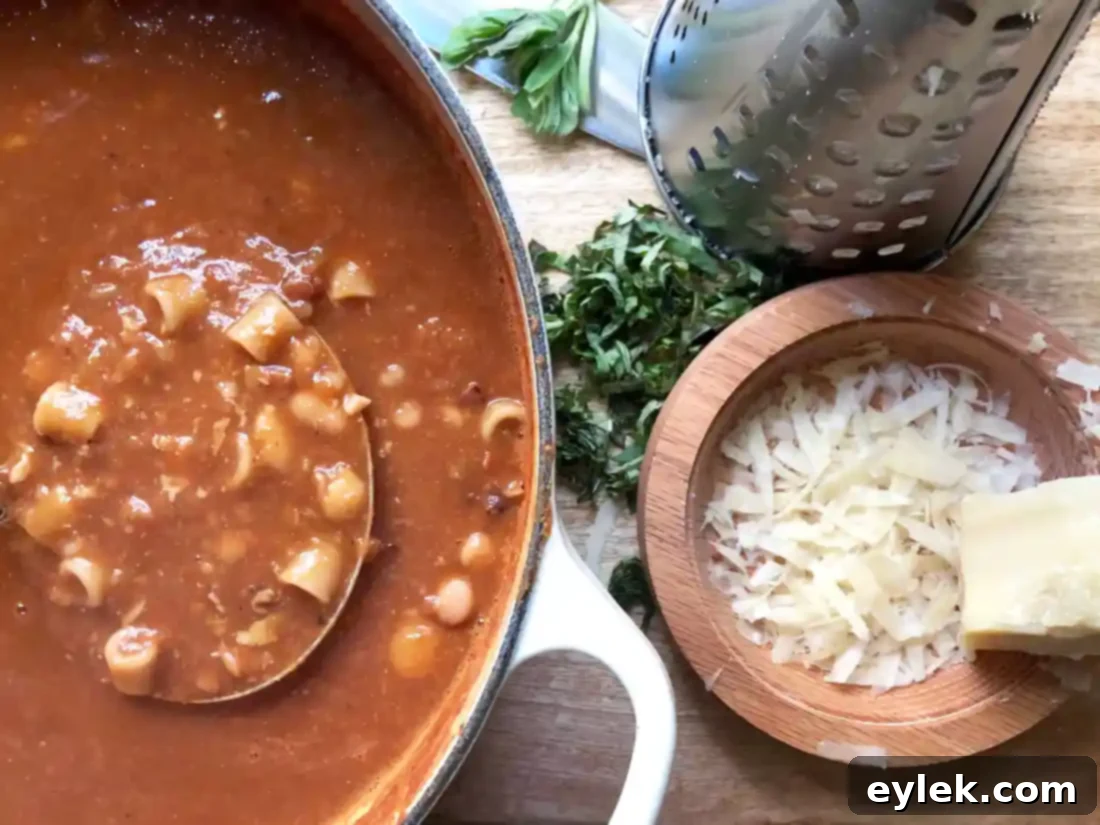 Bowl of Ina Garten's 16-Bean Pasta e Fagioli garnished with olive oil, Parmesan, and basil