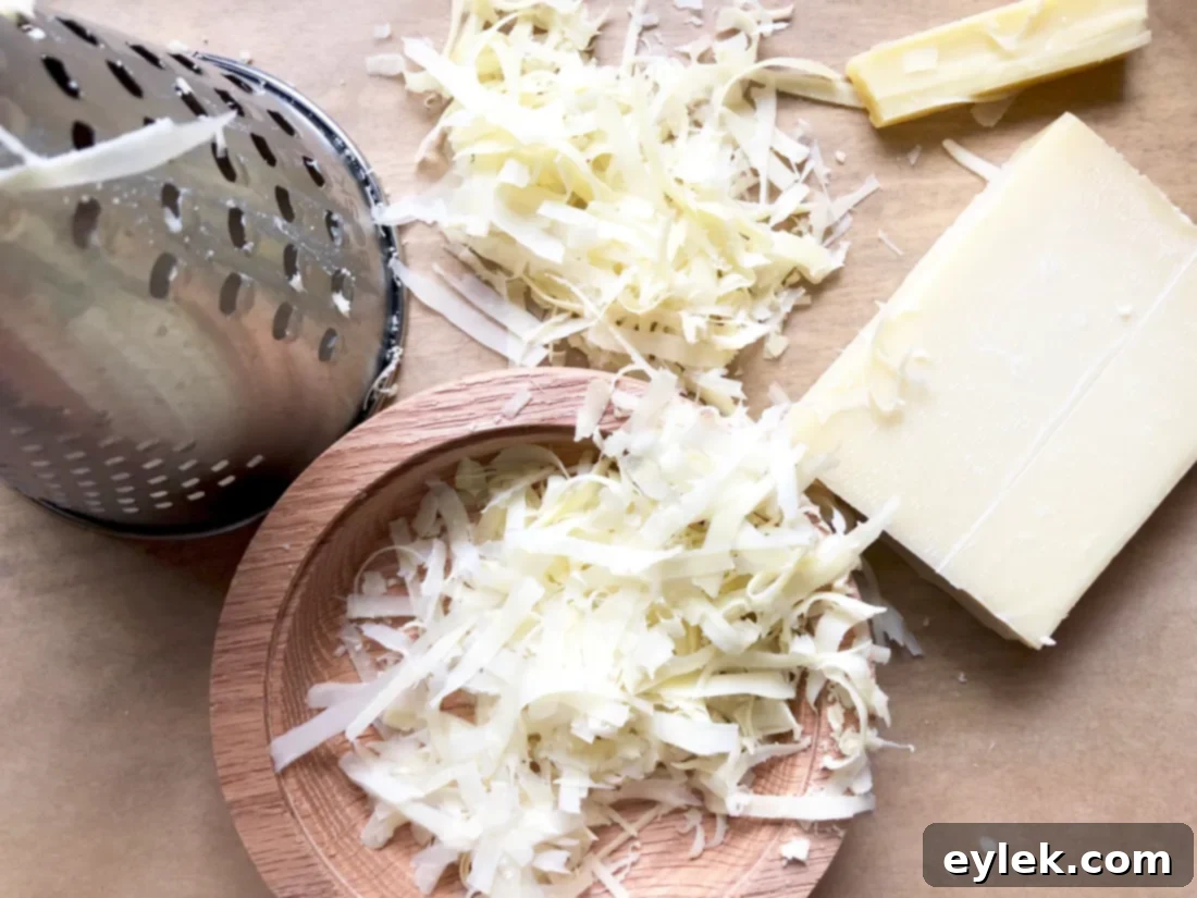 Adding shredded Gruyere cheese to the pumpkin soup