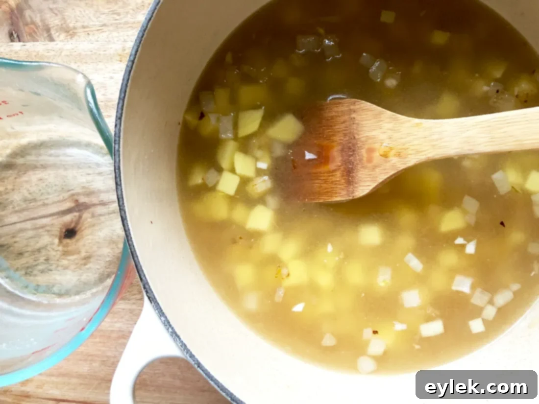 Stirring pumpkin puree into the simmering soup base