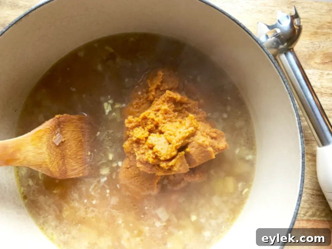 Using an immersion blender to smooth the pumpkin soup