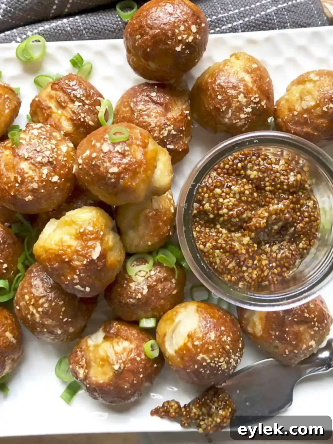 A close-up of pretzel bites with various dips, showcasing their texture and golden crust
