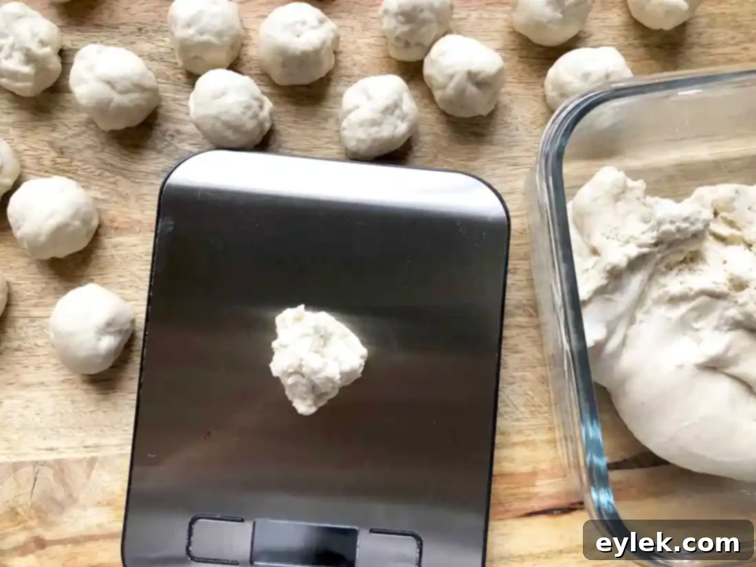 Pizza dough being rolled into small, uniform balls for pretzel bites