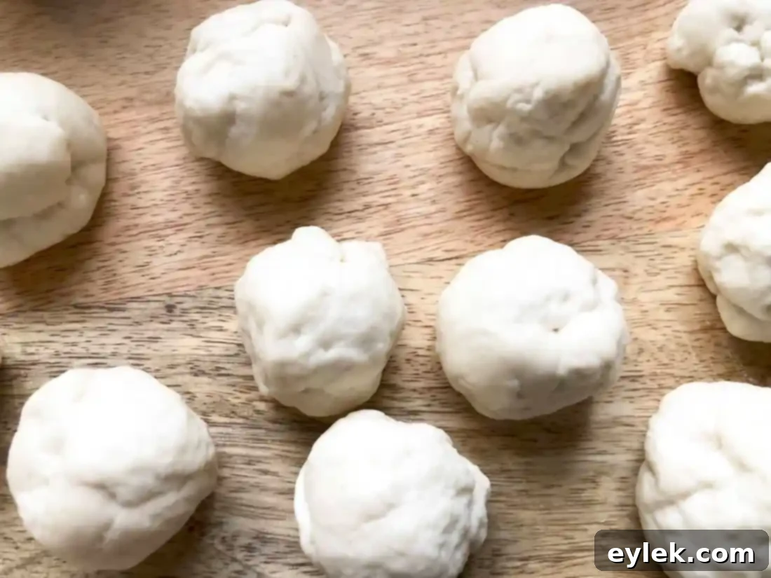 Close-up of neatly rolled pizza dough balls, ready for boiling