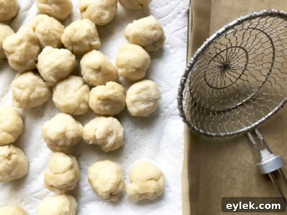 Pretzel dough balls boiling in a baking soda solution